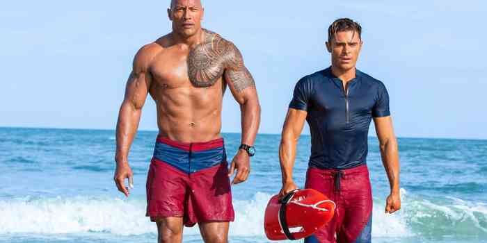 Zac Efron in Baywatch movie in the beach with  Dwayne Johnson